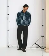 Pantalón de sastrería color negro, de corte recto y fluido. Presenta cintura estructurada con trabillas, cierre frontal con botón y cremallera, pliegues delanteros y bolsillos laterales funcionales.