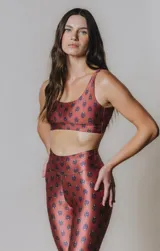 Top deportivo color ladrillo con estampado de cachemir en tonos azules. Tiene escote en U, breteles medios y tiras cruzadas en la espalda.