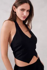 Chaleco negro con escote halter, corte al cuerpo y cierre frontal con botones.