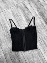 Corset negro de encaje con escote corazón, ballenas y breteles finos regulables.