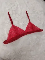 Bralette de encaje rojo con diseño triangular, copas suaves sin aro y tirantes finos regulables.