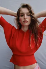 Jersey rojo de punto con escote en V pronunciado tanto en el delantero como en la espalda, mangas largas y diseño entallado en la cintura con caída acampanada.