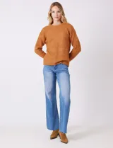 Buzo de lana melange color tostado, con cuello redondo y mangas largas.