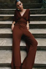 Pantalón palazzo de tiro medio en color marrón, confeccionado en tejido con textura. Cuenta con cintura elástica ajustable mediante cordones y diseño de pierna ancha.