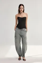 Jeans cargo de tiro medio y corte holgado en color gris con efecto deslavado. Cuenta con bolsillos laterales con solapa y cierre frontal de cremallera y botón metálico.