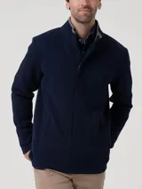 Buzo de hombre con cierre frontal completo y tapeta, cuello alto con terminación en contraste, manga larga y bolsillos laterales. Confeccionado en tejido de algodón orgánico y poliéster reciclado.