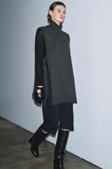 Chaleco de punto confeccionado en mezcla de lana, con cuello subido, diseño sin mangas y aberturas laterales con detalle de lazos.