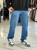 Pantalón de jean cargo color azul, con bolsillos laterales con solapa en los muslos, corte recto y holgado.