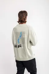 Buzo verde claro con cuello redondo, corte oversize y estampado lateral con texto en negro.