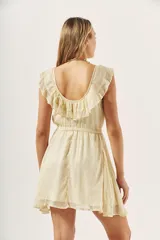 Vestido corto color crema con acabado brillante, escote redondo con volados decorativos en los hombros, cintura elástica y falda acampanada.