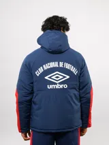Campera de abrigo Umbro del Club Nacional de Football, con diseño de bloques de color en azul, blanco y rojo. Cuenta con capucha ajustable, cierre frontal y logo de la marca junto al escudo del club en el pecho.
