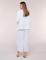 Chaqueta liviana color beige de silueta fluida y diseño abierto, con solapa caída, cintura con cordón ajustable y mangas 3/4 con presilla y argolla metálica.