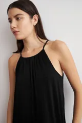 Vestido largo negro de lurex, con escote halter y diseño fluido y acampanado.