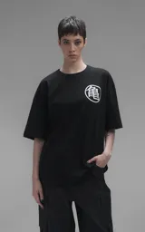 Remera negra de corte oversize con estampa frontal de Goku niño sobre la nube voladora rodeado de esferas del dragón.