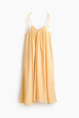 Vestido largo de corte holgado en tejido liviano, con diseño evasé, escote en V y breteles finos para atar en los hombros.
