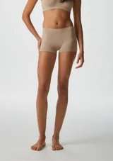 Bombacha tipo boxer de tiro medio, confeccionada en tejido sin costuras de color beige, diseñada para un ajuste cómodo y discreto.
