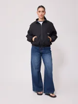 Campera rompevientos Rusty de nylon, color rosa y azul marino, con cierre frontal y puños elastizados.