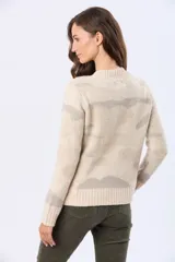 Buzo tejido de punto en jacquard color beige claro con estampado en tonos grises, de cuello redondo y manga larga.