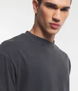 Remera de hombre, corte boxy, color gris oscuro con efecto desteñido, manga corta y cuello alto. Confeccionada en tejido de media malla (malla) de algodón.