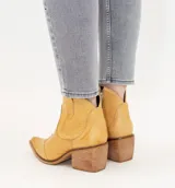 Botas texanas de caña baja confeccionadas en cuero vacuno con acabado estilo vintage, cuentan con cierre lateral y taco cuadrado de madera.