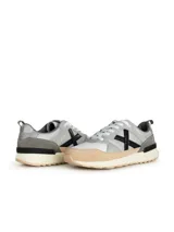 Championes Munich modelo Alpha, con capellada marrón de tela y cuero, detalles en azul y naranja, logo lateral en negro y suela blanca con base naranja.