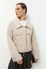 Tapado corto gris de paño, con cuello solapa grande, bolsillos de parche con solapa y mangas largas con puños anchos con presilla y aro metálico.