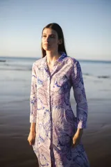 Túnica de lino y algodón con estampado de flores y la palabra 'Amor' en celeste, azul y lila. Tiene manga larga, largo hasta la rodilla y escote solapa.