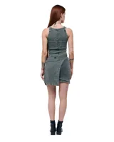 Minifalda asimétrica de denim color gris con efecto lavado. Presenta un frente cruzado tipo pareo con ruedo diagonal y aplique de caballo en níquel en la cintura.