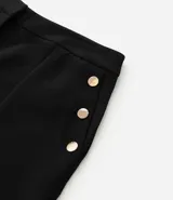 Bermuda de crepé color blanco, de corte holgado y tiro alto, con pliegues frontales y bolsillos laterales con detalle de botones. Confeccionada en poliéster y elastano.