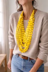 Collar largo de múltiples capas compuesto por discos circulares de madera en color negro, con diseño orgánico y liviano.