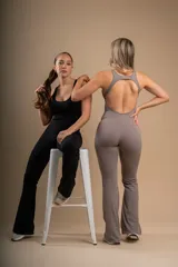 Enterito negro ajustado al cuerpo, con escote redondo y corte acampanado en las piernas.