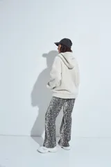 Canguro de corderito con capucha, cierre frontal y bolsillos laterales. Diseño relajado y textura suave.