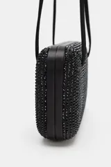 Bolso de hombro rígido con formato de caja rectangular, color negro, completamente revestido con apliques brillantes. Cuenta con doble asa de hombro delgada y cierre imantado.