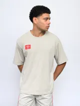 Remera de corte holgado color celeste, con cuello redondo diferenciado y logo de la marca estampado en el pecho. Presenta un diseño de manga corta y estilo deportivo.