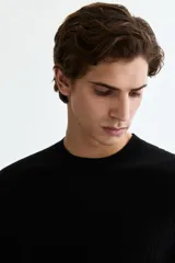 Remera de punto acanalado fino color negro, con cuello redondo y mangas cortas, de corte slim fit.