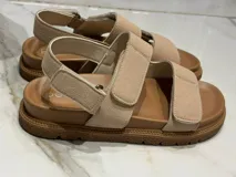 Sandalias color beige con ajuste de velcro en capellada y talón, plantilla acolchada y suela de goma antideslizante. Horma chica.