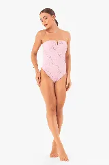 Traje de baño enterizo color rosa con textura arrugada, corte bandeau, herrajes dorados y copas extraíbles.