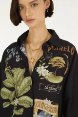 Camisa de manga corta negra con cuello camisero, cierre frontal de botones y diseño holgado, decorada con estampados botánicos y gráficos de estilo vintage.