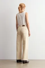 Jean de corte culotte y tiro medio, color beige, con diseño de perneras anchas y terminación desmechada en el bajo.