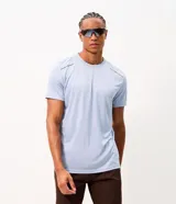Remera deportiva de manga corta y cuello redondo, color celeste, con tecnología dry y detalles reflectantes en los hombros.
