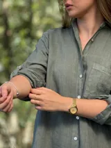 Vestido camisero color beige claro, de lino 100% natural, con botones de nácar, bolsillo delantero y mangas 3/4 con botón para recogerlas. Diseño asimétrico, más largo en la parte trasera.