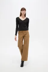 Remera negra de manga larga y calce al cuerpo, confeccionada en poliéster con diseño calado y escote en V.