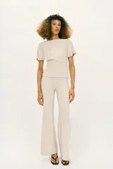 Pantalón largo negro de tiro alto, confeccionado en tejido elástico, con cintura elástica y diseño de pierna ancha tipo palazzo con bajo evasé.