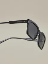 Lentes de sol rectangulares negros con lentes marrones.