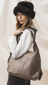 Cartera tipo hobo de cuero sintético color tostado, con diseño de hombro, costuras verticales decorativas y monedero pequeño extraíble a tono.