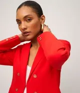 Blazer femenino de sastrería confeccionado en punto roma, con cuello solapa, cierre frontal con botones decorativos y diseño estructurado.