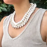 Collar corto de cadena gruesa color beige con eslabones planos y cierre de mosquetón dorado con cadena de alargue.