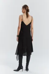 Vestido midi negro de gasa y satén, con escote recto, volados y ruedo irregular.