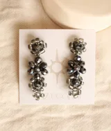 Aros colgantes con forma de racimo, hechos con cristales facetados color gris oscuro y engarzados con hilo metálico plateado.