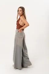 Jean súper campana de tiro alto, color celeste vintage, con pierna extra ancha y caída fluida. Cuenta con bolsillos delanteros y traseros, y cierre frontal con cremallera y botón metálico.